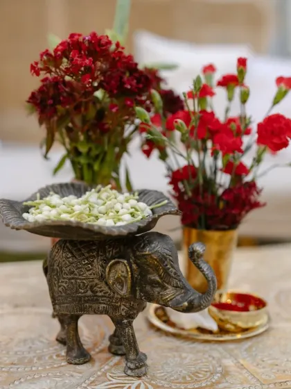 A small, thoughtful detail for the Shiva-Parvati themed wedding. An antique-style elephant statue holds fresh jasmine flowers, adding a touch of traditional charm and fragrance to the decor.