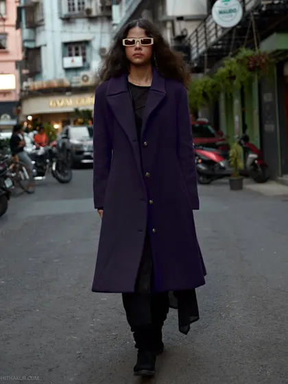 A walking shot that captures the energy and movement of the city. The background is blurred just enough to keep the focus on the model's confident stride.