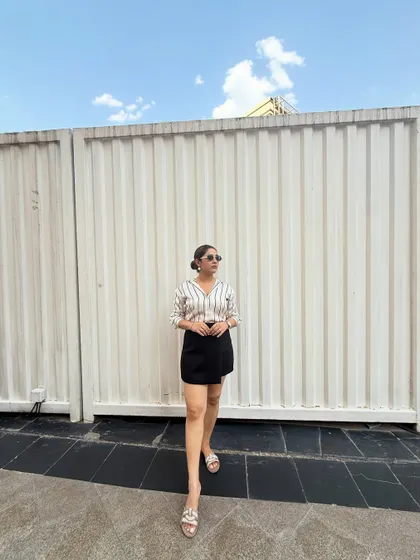 This look is perfect for a smart-casual setting. The combination of a classic striped shirt and a modern skort is comfortable yet polished. I help clients build a wardrobe full of such easy-to-wear outfits.