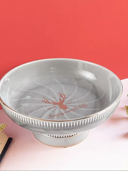 A simple and elegant serving bowl in a soft grey, featuring a subtle deer motif. The pedestal base gives it a classic look, perfect for serving snacks or as a decorative fruit bowl.