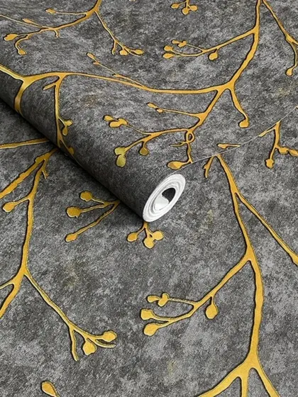 A close-up of a dark grey wallpaper roll with an embossed gold branch pattern.