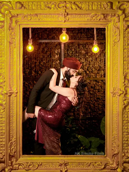 A passionate, artistic shot of the couple framed within a giant golden picture frame.