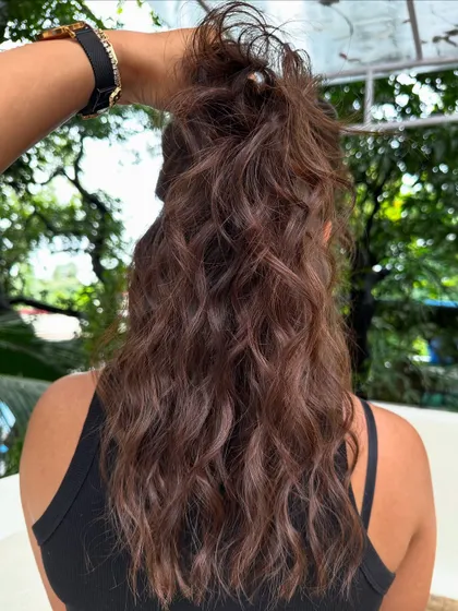 A messy ponytail showing off the highlights in this holiday-ready hair.