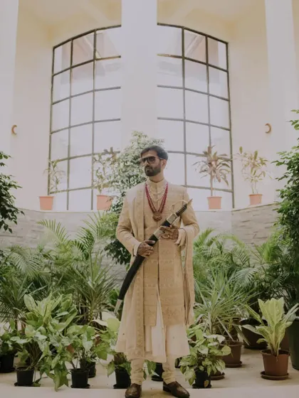 A groom's portrait is about capturing his presence and personality. Here, we used the architectural lines and lush greenery to frame him, creating a powerful, magazine-worthy shot that speaks of tradition and modern style.
