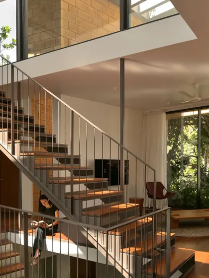 The staircase in the Debris Block House is more than just for transit; it's a piece of furniture for living. The wide, lower steps are designed as a place to sit, read, and connect with the rest of the home.