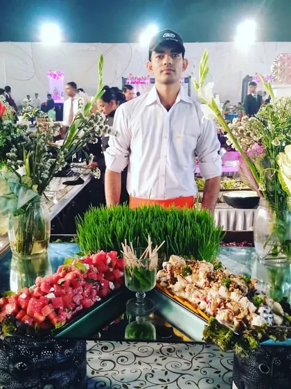 A member of my service team proudly standing behind his salad station, ready to serve guests.