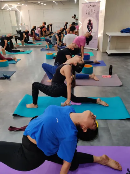 Our workshop participants explore various heart opening poses. This image captures a moment of deep stretching and release, with students at different levels using props to support their individual practice.
