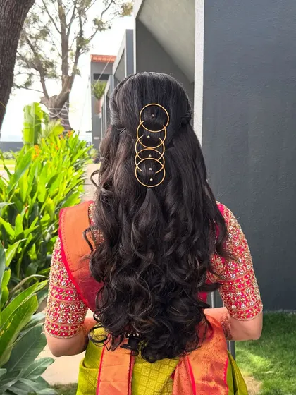 An outdoor shot of the modern hairstyle with gold rings, showing how it catches the light and adds a unique design element.