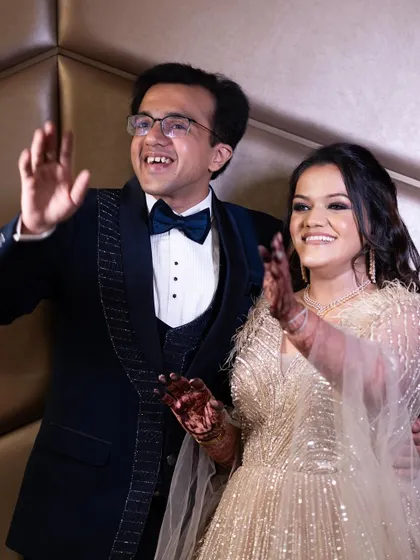 A celebratory wave from the happy couple. Her makeup is designed to look flawless and radiant all night long.