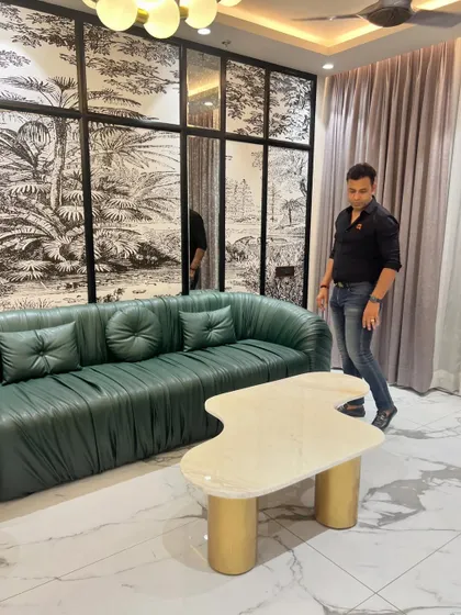 The way light interacts with the textures of the pleated sofa and marble floor is a key part of this living room's design.