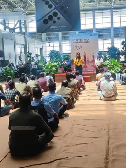 A group of airport ground staff taking a moment for a guided meditation. These short mindfulness breaks are powerful tools for managing the daily pressures of their jobs.