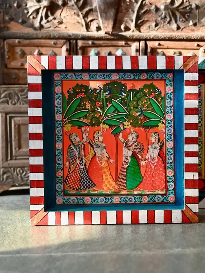 The bottom block of the set, showing gopis in a lush grove. The red and white striped border adds a playful, contemporary touch.