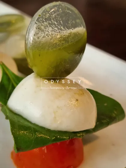 A modern take on a Caprese salad, with a sphere of basil oil resting on fresh mozzarella and tomato. This dish showcases our innovative approach to classic flavor combinations.