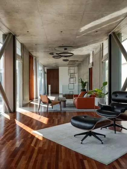 The interior of the cantilevered living area, where exposed structural cross-bracing becomes a deliberate design feature. The space is framed by a wooden screen, offering filtered light and views while maintaining a sense of enclosure.