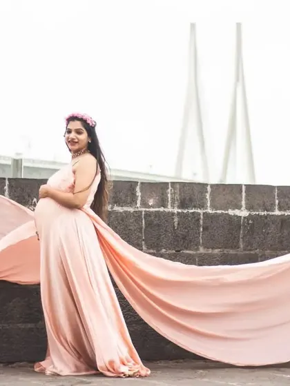 This elegant peach maternity gown features a double trail for added flair. It’s an excellent choice for capturing stunning portraits with an urban backdrop, like the Mumbai sea link seen here.