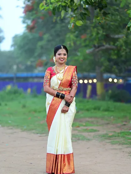 A full-length portrait of the Coorgi bride, showcasing the unique way the saree is draped and the complete, elegant look.