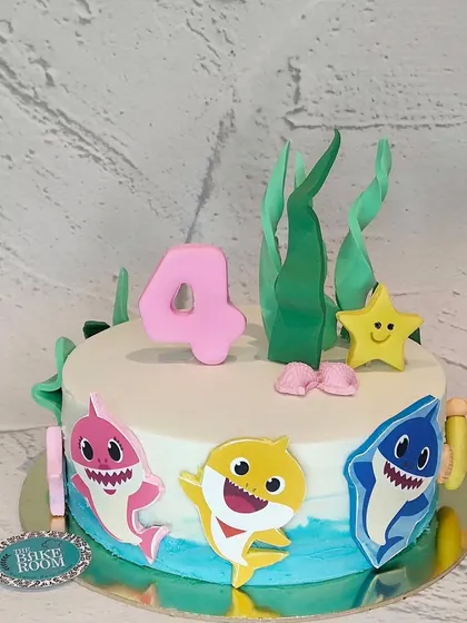 A fun and colorful Baby Shark cake for a 4th birthday. This underwater-themed cake features the whole shark family and is perfect for any little fan of the song.