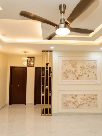A bright and airy living space featuring beautiful floral wall panels and a minimalist gold partition. The design focuses on clean lines and soft, neutral tones to create a tranquil and modern home environment.