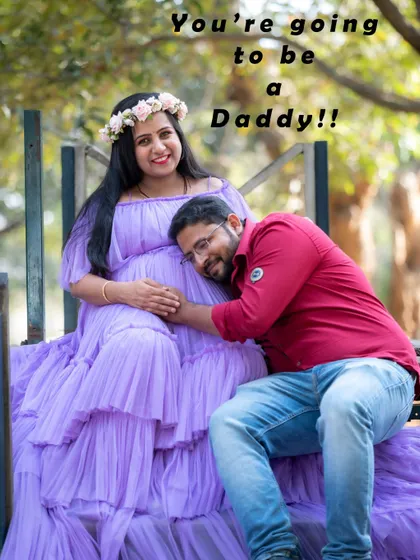 A fun and loving couple photo with the dad-to-be listening to the baby bump. The text "You're going to be a Daddy!!" adds to the joy.