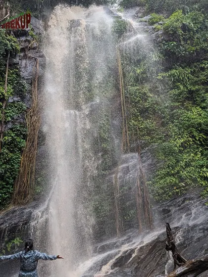 A trekker embracing the beauty of Hidlumane falls. The raw power and beauty of the waterfall is a humbling experience.