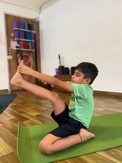 This young student is working on his hip flexibility and balance in this seated pose.