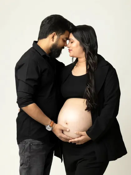 An intimate and modern studio portrait of an expecting couple, focusing on their connection and the beautiful baby bump. This simple, clean style creates timeless and emotional pregnancy photos.