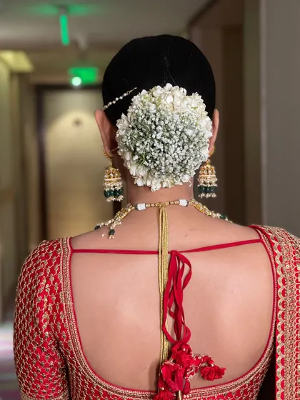 This is a classic for a reason. I crafted this traditional bridal bun and adorned it with a full circle of fresh baby's breath gajra, creating a clean, elegant, and timeless look for the main wedding ceremony.