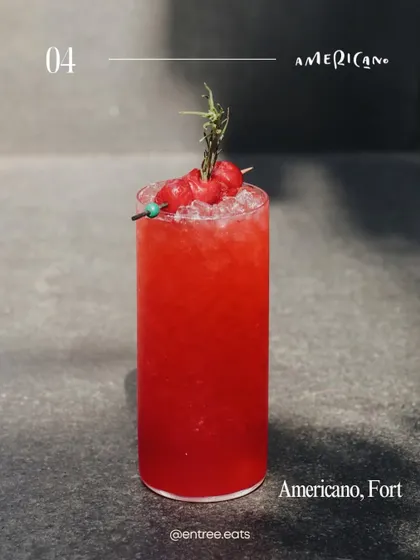 A bright and refreshing red cocktail from Americano, Fort. This image showcases a different style of drink, adding variety to the guide and highlighting different bar experiences.