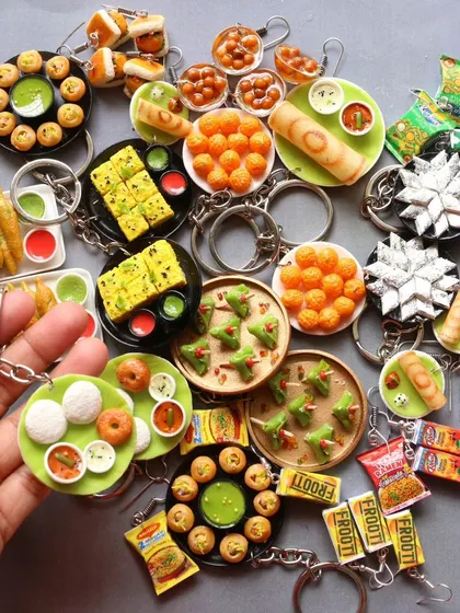 A large collection of assorted food keychains, featuring everything from idli and vada to dhokla and samosas.