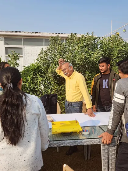 An art instructor explaining a concept to a group of aspiring artists, with the sunny golf range in the background.