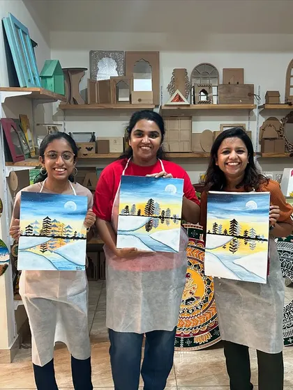 A group of three artists proudly showing off their finished forest paintings. They all did an amazing job.