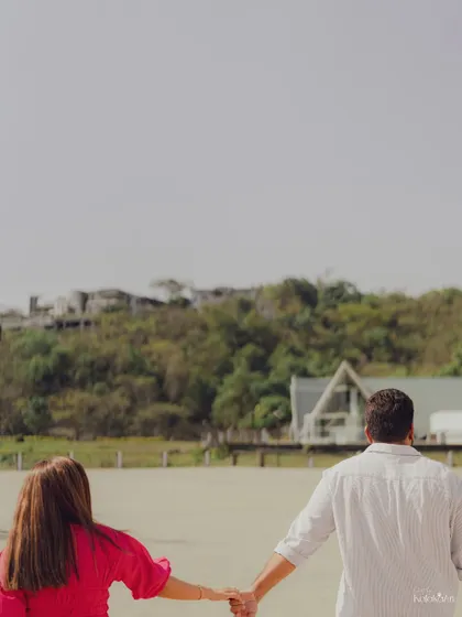 A "follow me" style shot where the couple holds hands, walking towards a beautiful lakeside view, symbolizing the start of their journey together.