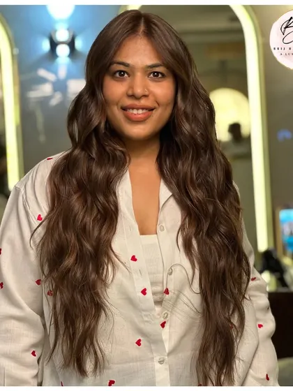 A happy client showing off her luminous brown shine. Her smile says it all; a great hair color is a huge confidence booster.