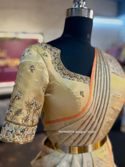 A side view of the cream blouse, highlighting the beautiful sleeve embroidery.