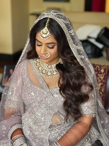 A serene portrait of the bride. The soft lighting enhances the ethereal quality of her pastel look.