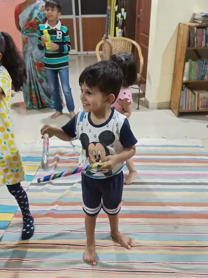 A young boy joyfully participates in the dandiya dance, fully engaged in the post-story activity.