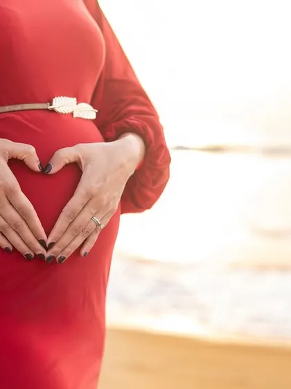 A heart for the little one. This classic pose is a sweet and symbolic way to show your love for the baby on the way, beautifully framed by the morning sun.