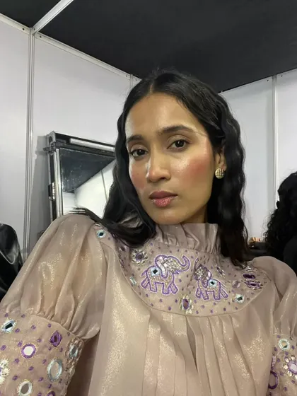 The complete look, pairing the draped blush with an intricately embroidered top. The makeup enhances the outfit without competing with it.