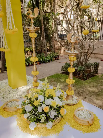 Traditional brass lamps and marigold flowers create a classic and auspicious decor setup for a Haldi ceremony.