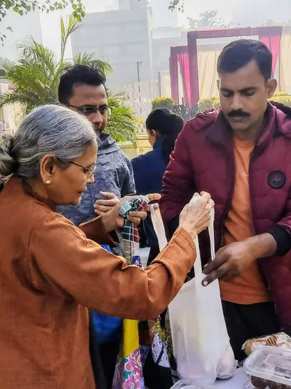 A customer receiving her purchase in a cloth bag, a common sight at the market.