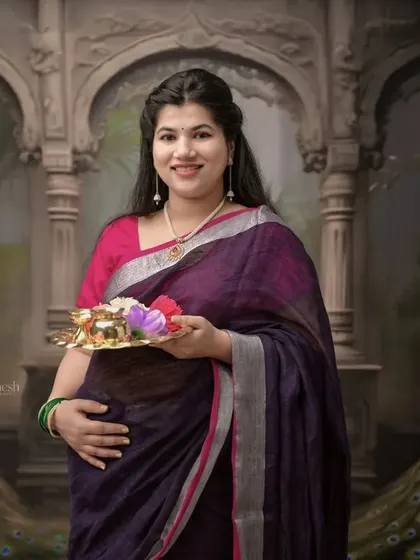 Here is another take on the traditional theme, set against a backdrop inspired by royal Indian architecture. The rich colors of her saree stand out beautifully.