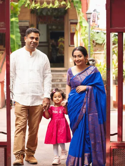 A beautiful family portrait at the entrance of a traditional home. The setting adds a sense of warmth and heritage to this lovely family photo.