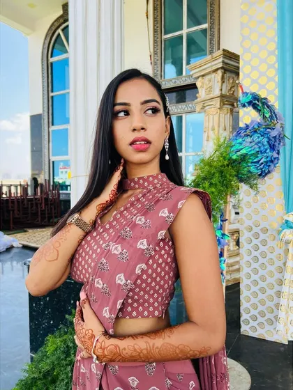 A confident pose showing off the full look. The modern, pre-draped saree and chic makeup make for a perfect engagement guest outfit.