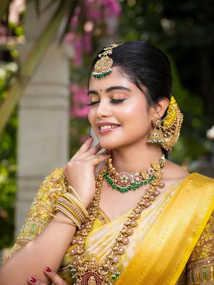 A beautiful smiling shot of the model, her eyes closed, showcasing her makeup and the intricate details of the jewellery.
