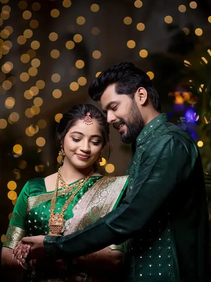 A tender moment between the couple during their engagement celebration. The warm bokeh from the lights creates a dreamy and romantic atmosphere.