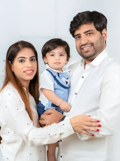 A classic family hug, with both parents holding their baby boy. This portrait radiates warmth and family love.