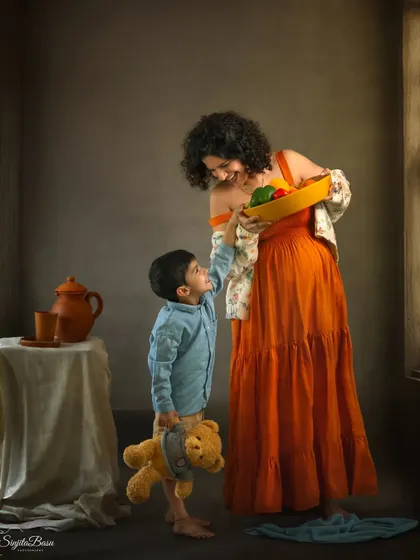 This storybook maternity portrait captures the playful relationship between a mother and her son. His cheeky grin as he reaches for the vegetables she holds tells a story unique to their family.
