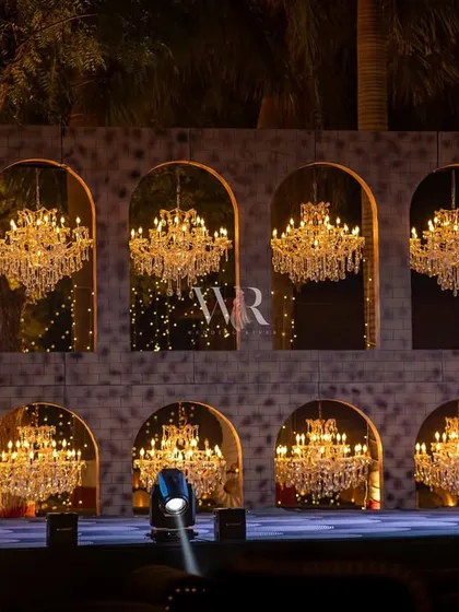 A close-up of the magnificent chandelier wall that served as the stage backdrop. The warm light from the crystals contrasts beautifully with the cool blue stage lighting.