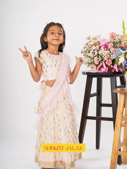 This little girl is ready to party in my cream and gold printed lehenga. The pre-draped ruffled dupatta adds a fun, modern twist that she is sure to love.