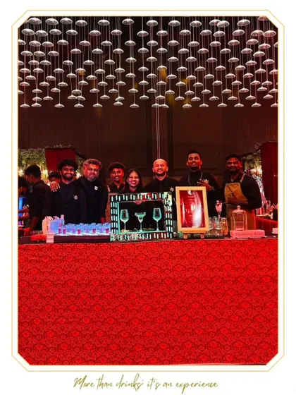A vibrant bar setup for a Hyderabad wedding, featuring a bold red counter and a stunning overhead installation of cascading lights. This design creates an immersive and energetic atmosphere for guests.